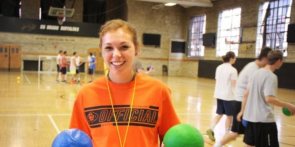 smiling woman holding dodgeballs