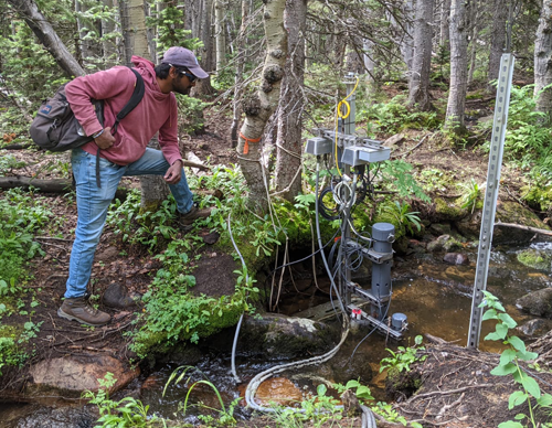 A researcher studying creek water at the Mountain Research Station