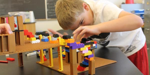 boy building LEGO structure 