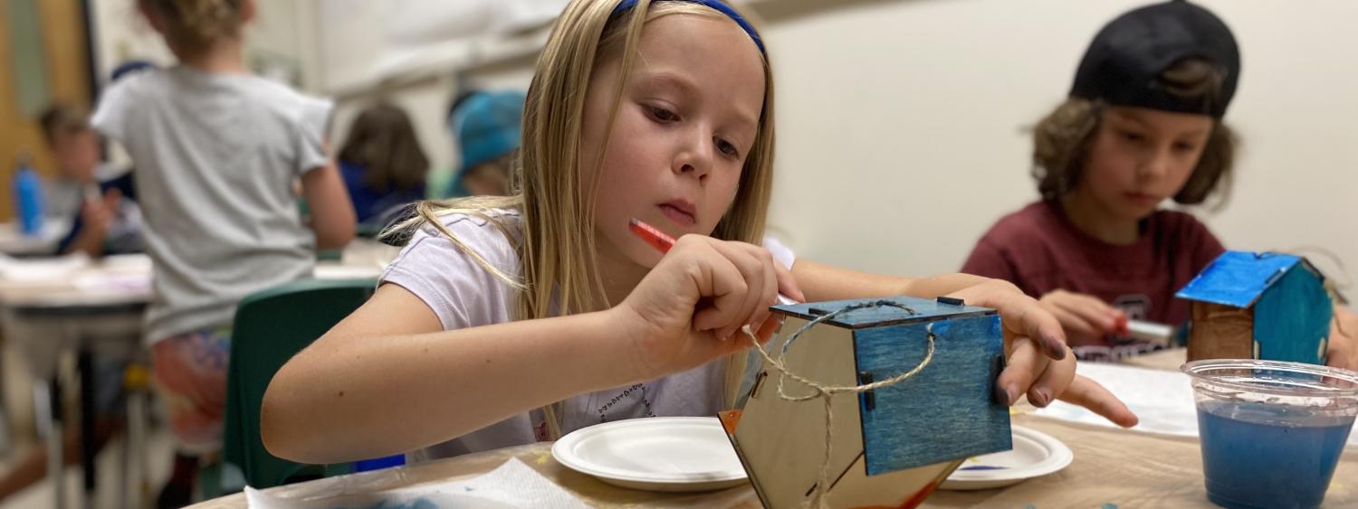 campers painting birdhouses