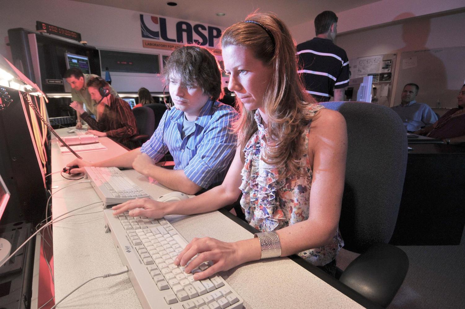 Faculty member works with student in LASP’s Mission Operations center