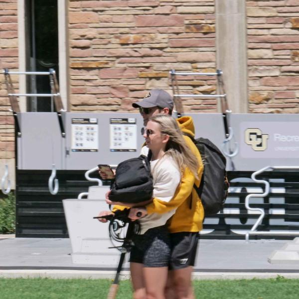 Students use an electric scooter to get around campus