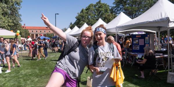 Two girls posing at the Be Involved Fair