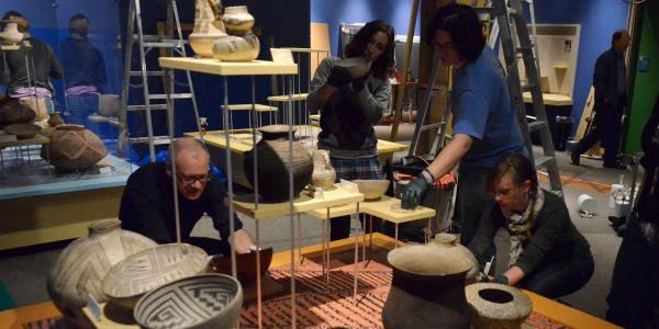 People looking at museum pottery