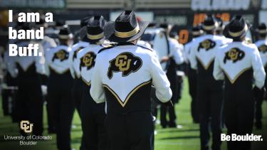 The back of band members in formation on a field with "I am a band Buff"