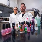 CU Boulder Professor Lupita Montoya and undergraduate student standing behind bottles of nail polish