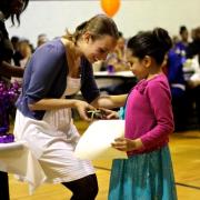 A girl receiving an award during a positive recognition campaign event in Montbello