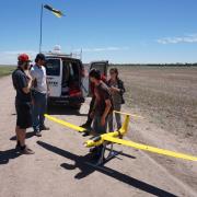 Students inspecting a drone in front of the van