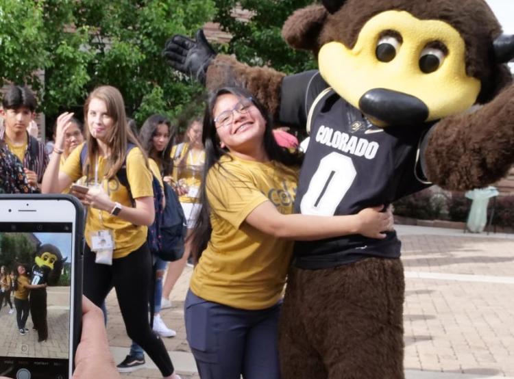 CU mascot Chip posing for a photo with a young fan