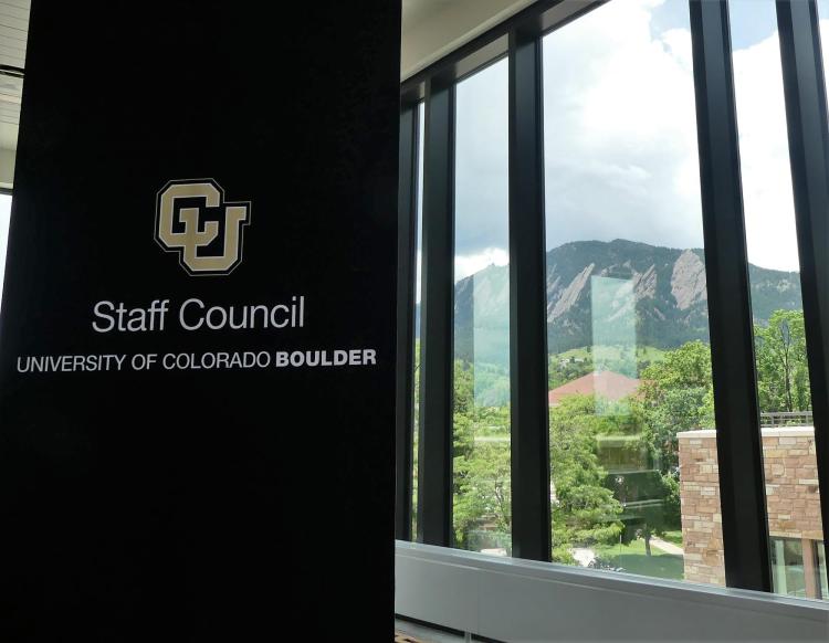 Staff council banner next to window overlooking Flatirons