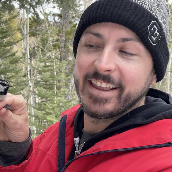 A picture of Dr. Scott Taylor, a white man with short brown hair, holding two small birds.