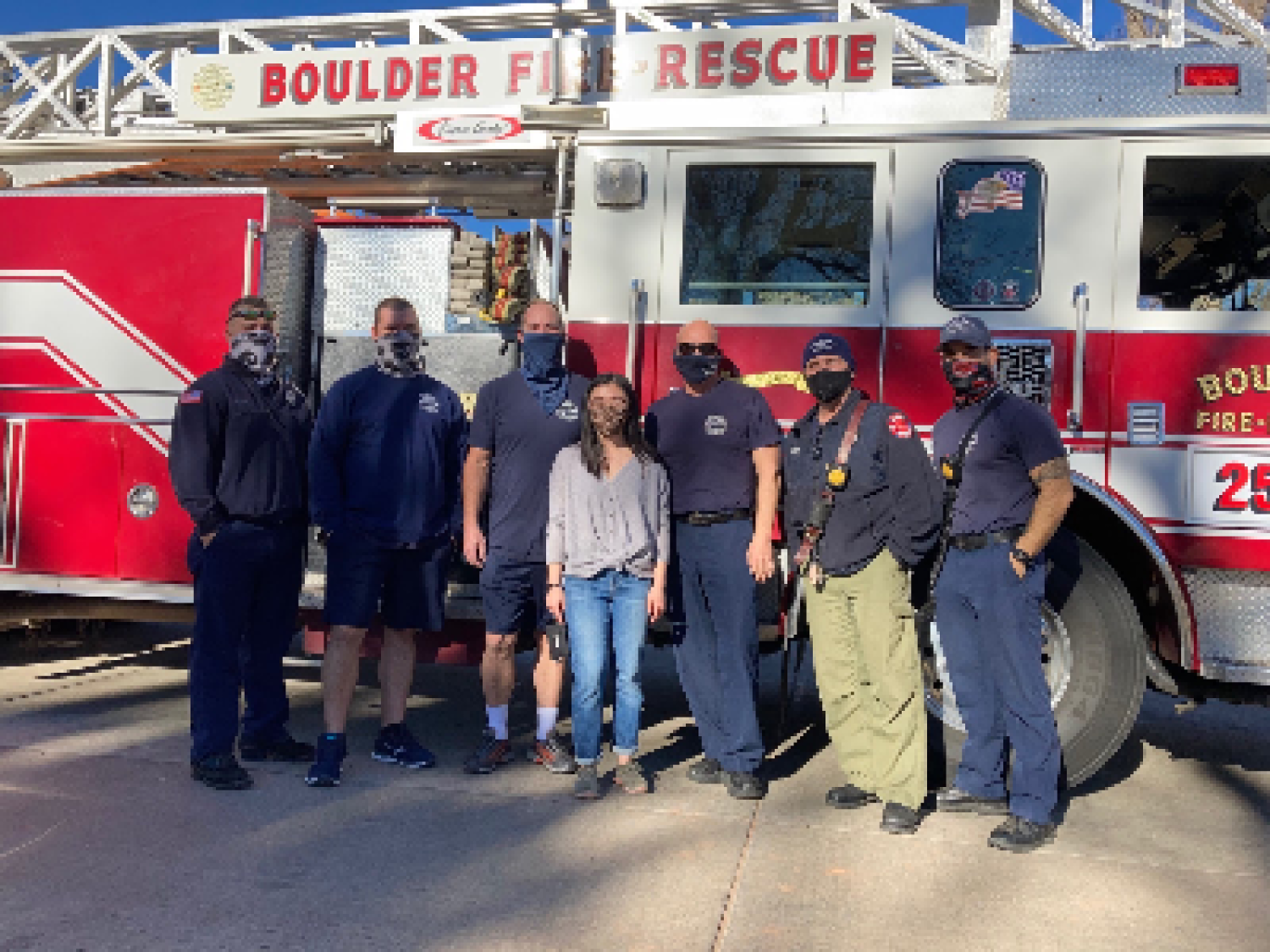 Jordan Lee standing among firefighters