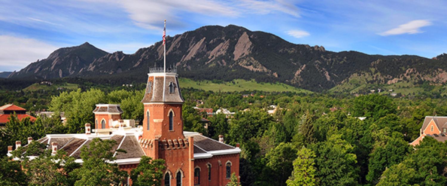 Arial view of the CU Boulder campus including Old Main and the Flatiron mountains in the background.