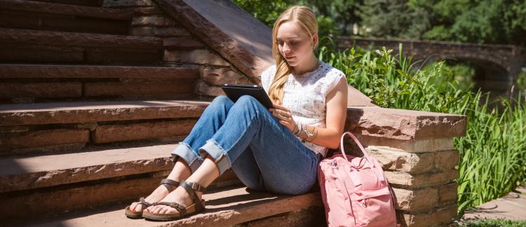 Student studying on steps.