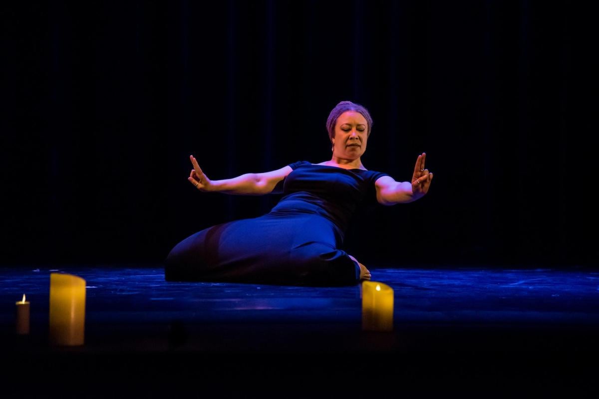 Faculty member dancing in a candle lit theatre