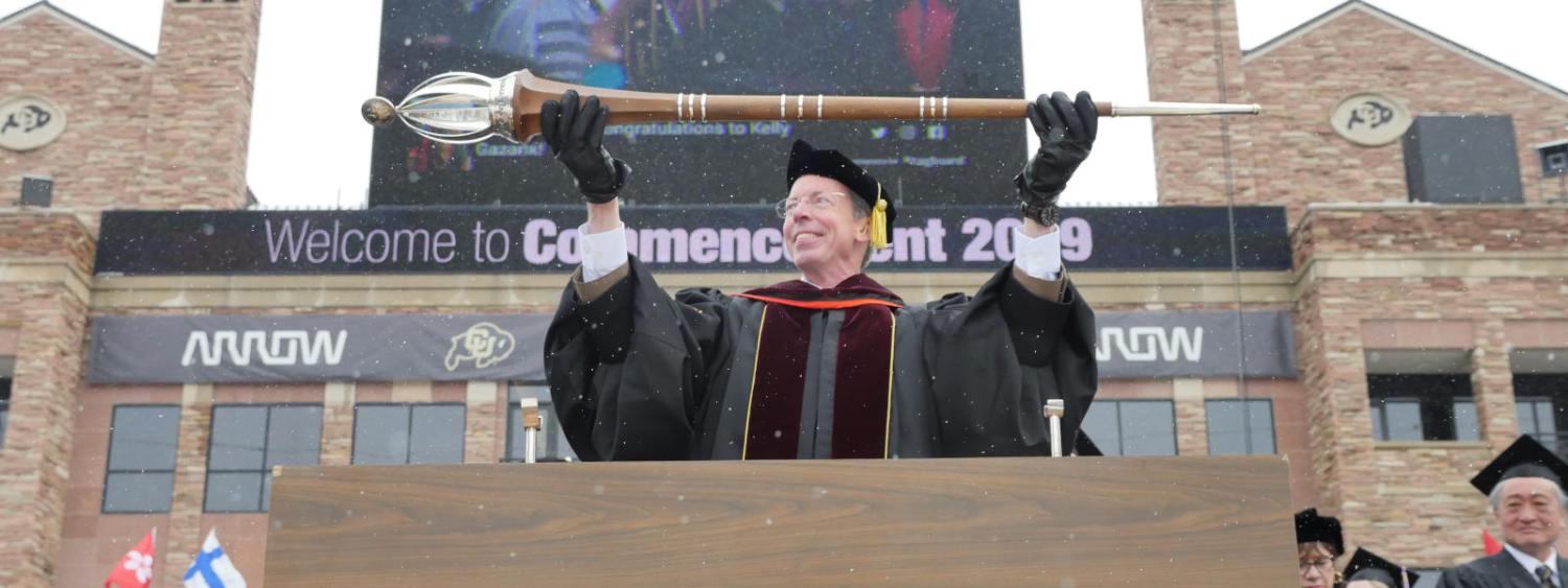 A faculty member lowers a Mace during the 2019 Commencement Ceremony