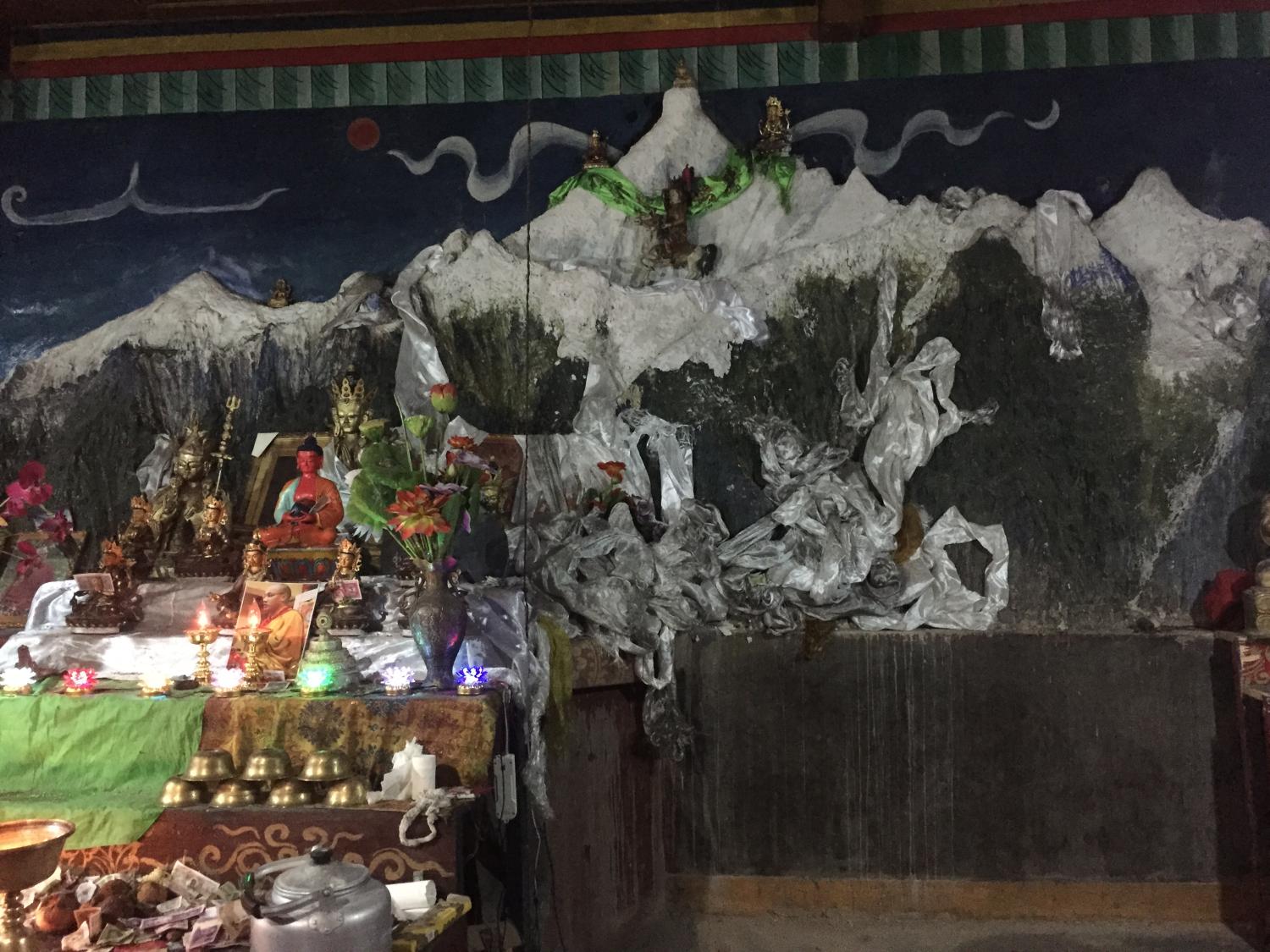 Sonam Norbu built a small temple, in which is this wall sculpture of the entire mountain range around Khawakarbo, to atone for his past sins as a hunter. It is located by a remarkable old grove of ancient cypress trees on the banks of the Mekong River at the edge of Bu Village.