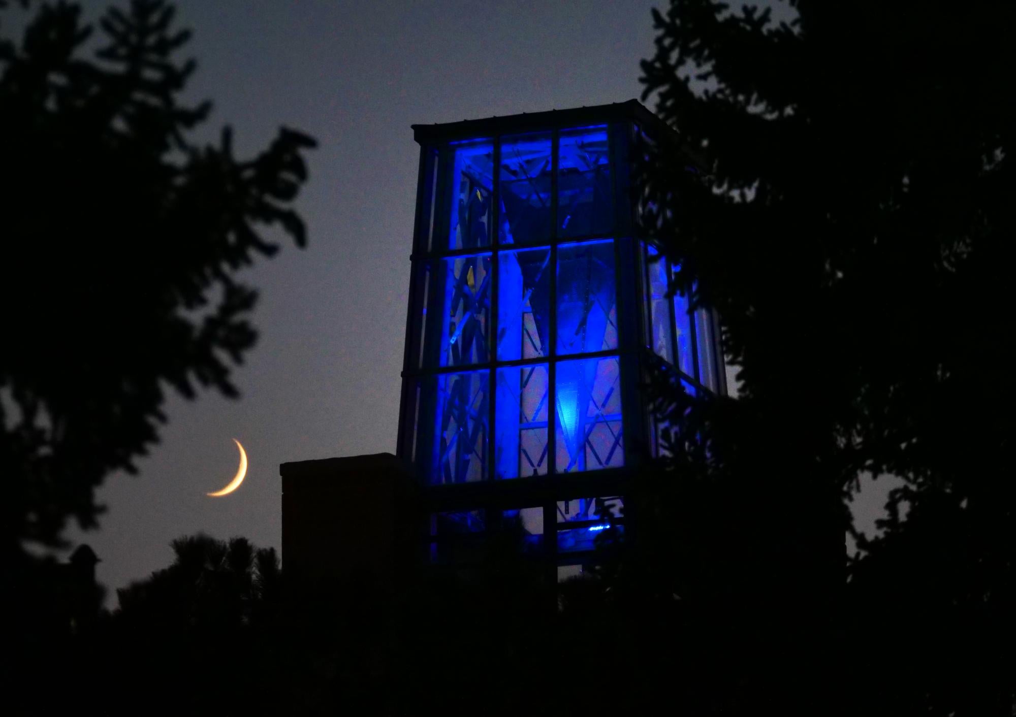 A crescent moon as the ATLAS tower shines blue in remembrance (Photo by Casey Cass/University of Colorado)