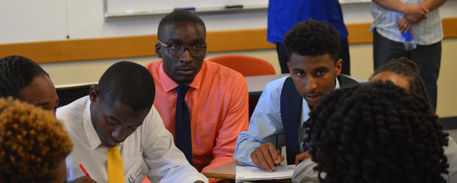A group of students takes notes during the boys2MEN summit