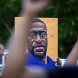 Protestors hold up painting of George Floyd 