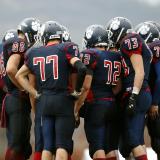 High school boys huddle during football game
