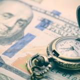 An image of a U.S. 100-dollar bill and a pocket watch