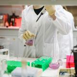 researcher in a white lab coat working in lab