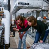 Two students checking the temperature and pressure settings for a rooftop HVAC unit in the Larson Laboratory (Photo via CU Boulder)