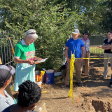 Sister Mary Nelle Gage reads to a crowd of people outdoors