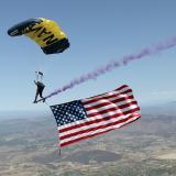 Man parachutes to ground with American Flag