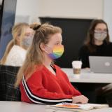 A student wearing a rainbow-colored face mask