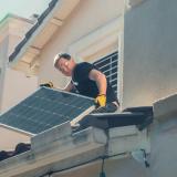 Man installing solar panels on a house