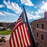 The US flag flies in front of the University Memorial Center. (Photo by Glenn Asakawa/University of Colorado)