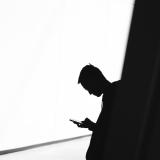 shadowy figure typing on phone