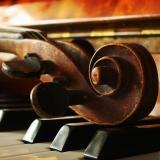 Violin head lying across piano keys