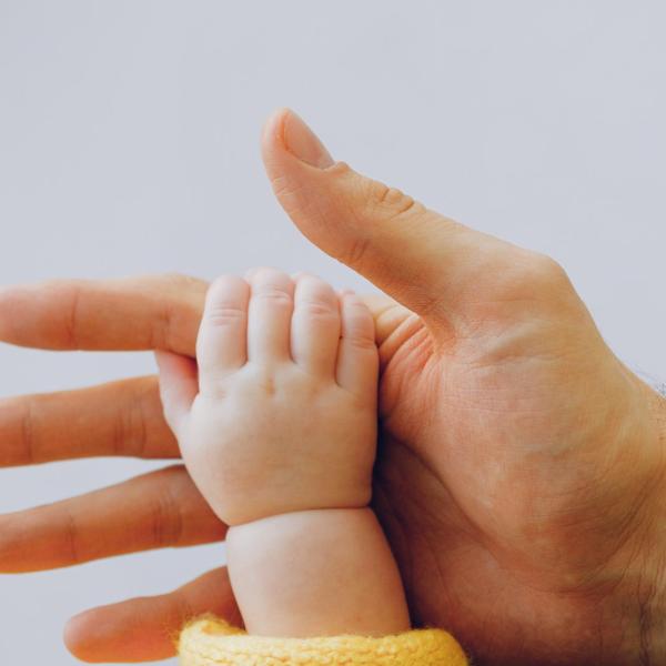 Baby holding mother's hand