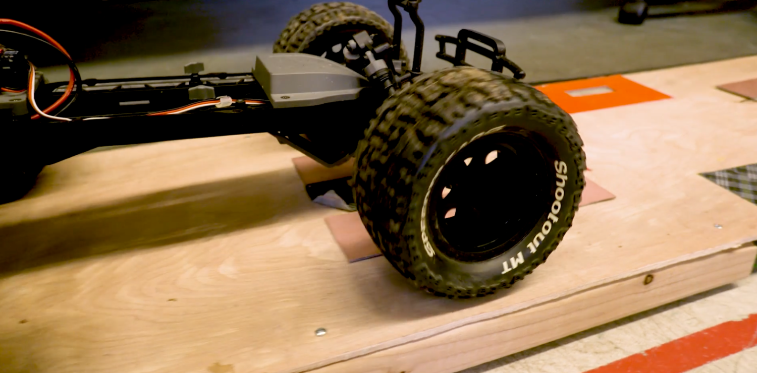 A remote control car drives across a prototype of the wireless charging system.