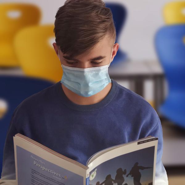 Student reading while wearing mask