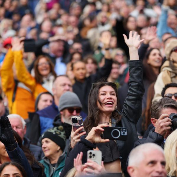 Family and friends cheer for graduates as the enter Folsom Field