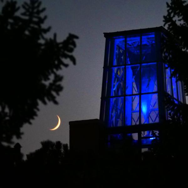A crescent moon as the ATLAS tower shines blue in remembrance (Photo by Casey Cass/University of Colorado)