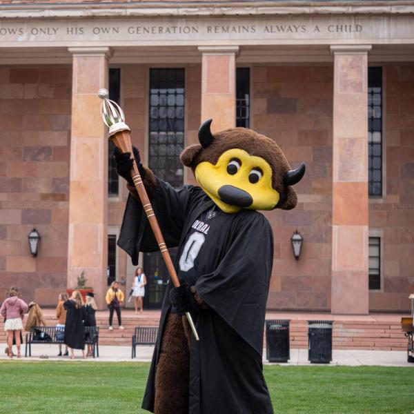 Chip, in regalia, joins others in celebrating 2021’s CU Boulder commencement ceremony. (Photo by Glenn Asakawa/University of Colorado)
