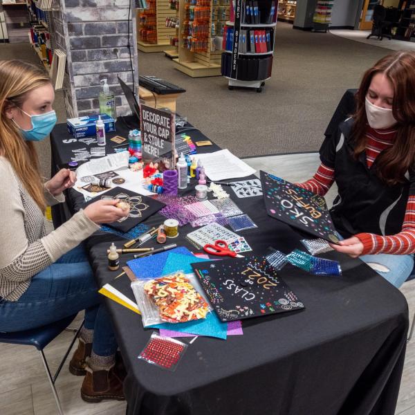 Students decorate their graduation caps and stoles at the University Bookstore. (Photo by Patrick Campbell/University of Colorado)