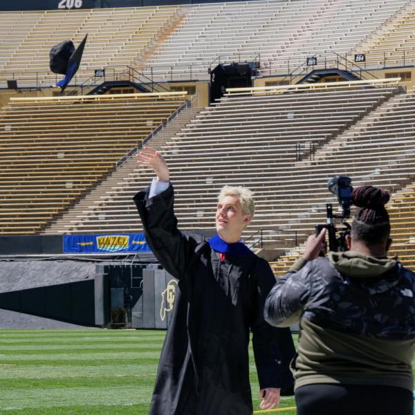 Alexander Whiteman tosses his cap for a formal photo on Folsom Field at Folsom Field during CU Boulder’s Graduate Appreciation Days events on April 23, 2021. (Photo by Glenn Asakawa/University of Colorado)