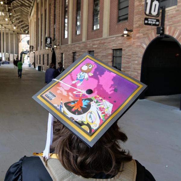 A graduate sports a creatively-decorated cap during CU Boulder’s Graduate Appreciation Days events on April 23, 2021. (Photo by Glenn Asakawa/University of Colorado)