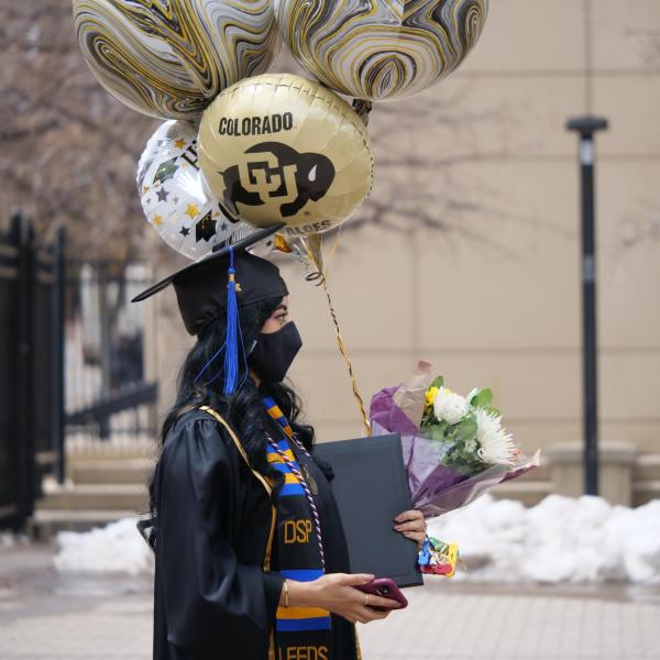 Adilene Garcia Aniles carries an armload of celebratory accessories during CU Boulder’s Graduate Appreciation Days events. (Photo by Glenn Asakawa/University of Colorado)