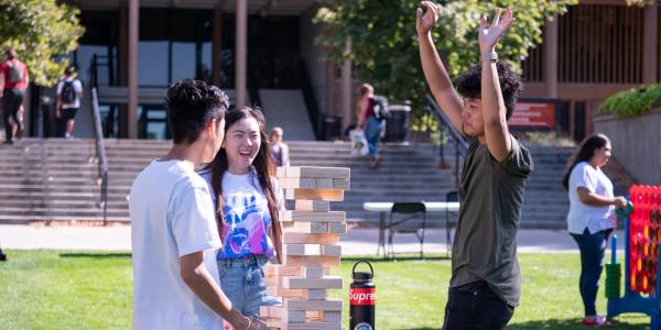 students playing giant Jenga at an outdoor Fall Welcome event in 2019