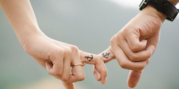 A couple holding hands with matching tattoos