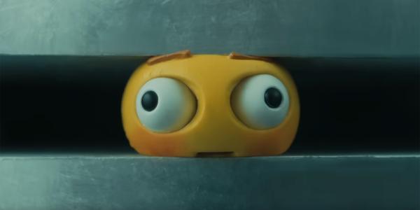 An emoji is squeezed by an industrial press in a still from Apple's controversial new ad