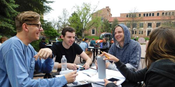 group of students studying at an outdoor table