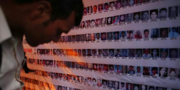 a wall of photos of missing people in Nepal